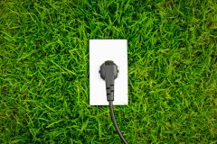 Energy concept outlet in fresh spring green grass